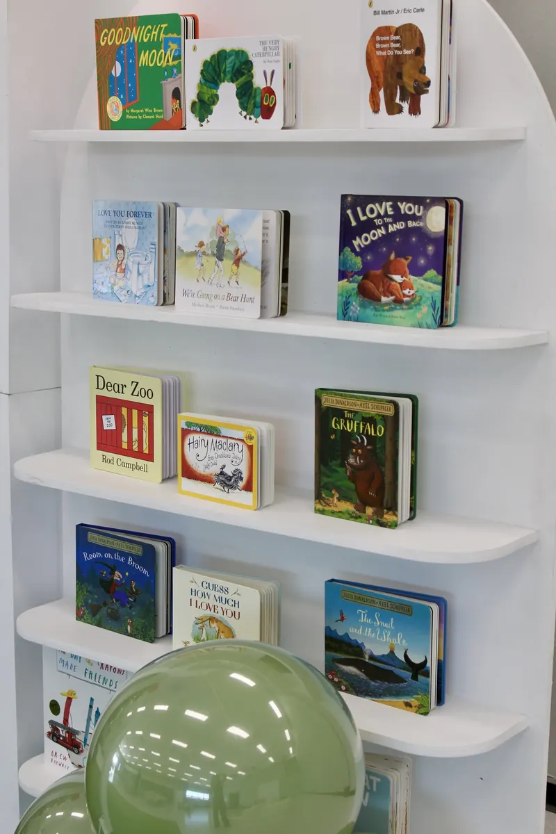 Arched white bookshelf filled with picture books